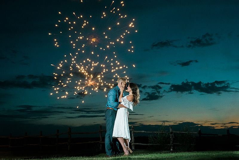 Couple kissing in front of fireworks